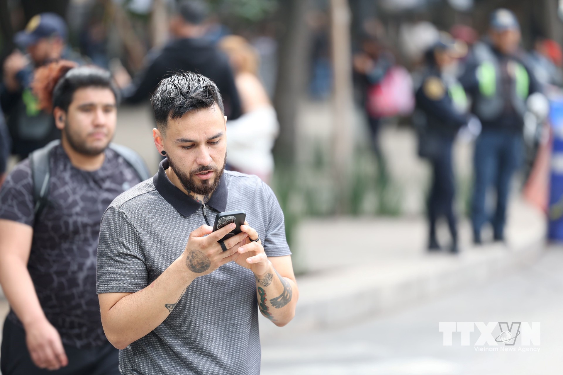 Một bạn trẻ vừa đi bộ vừa lướt điện thoại tại thủ đô Mexico City, Mexico. (Ảnh: Phi Hùng/TTXVN)